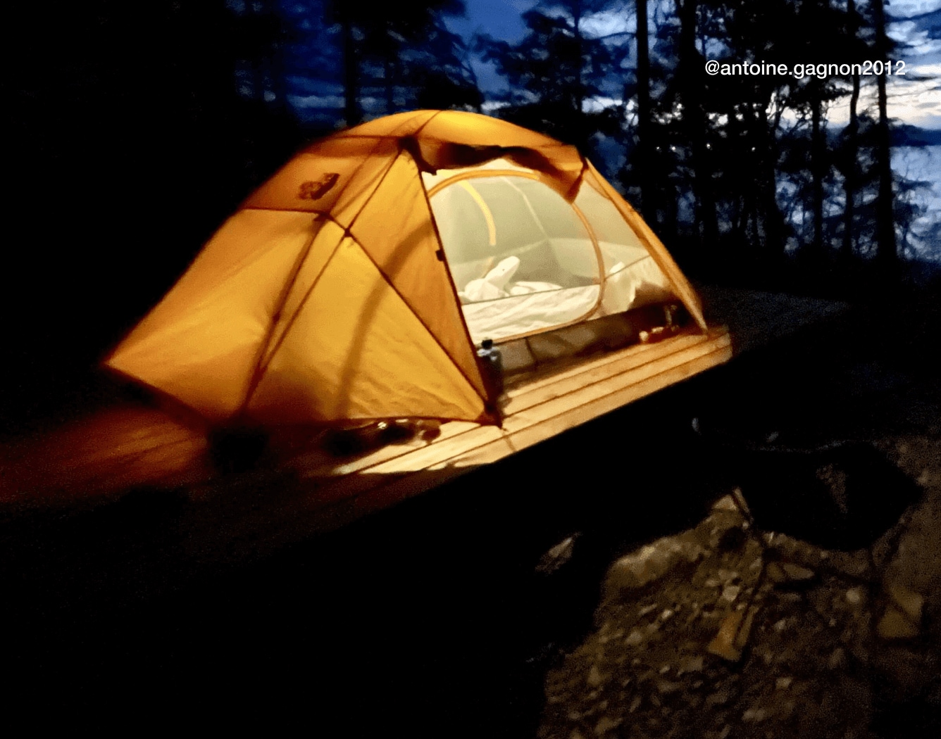 A tent from The North Face, lit up from within, set against a nighttime lake scene. UGC credit: @antoine.gagnon2012 